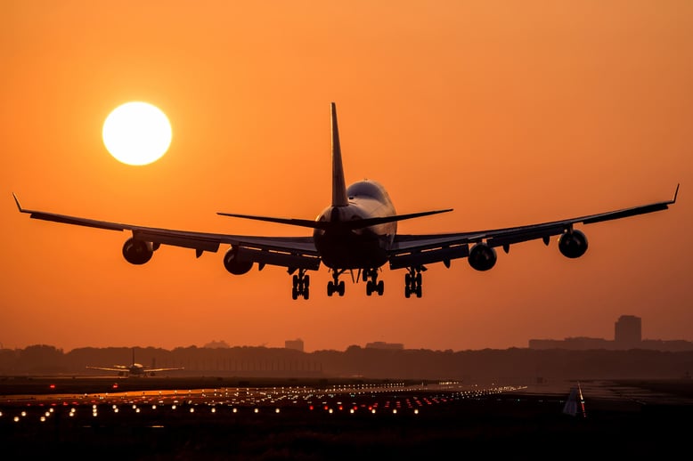 aircraft is landing in the sunset